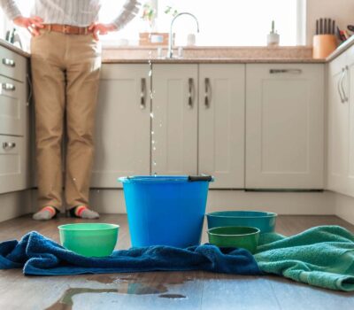 Puddle of water, buckets, and towels in middle of kitchen floor