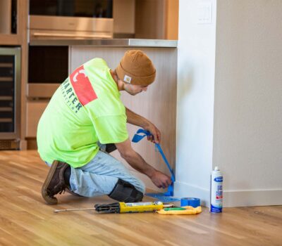 Construction worker tapping off kitchen cabinet for painting